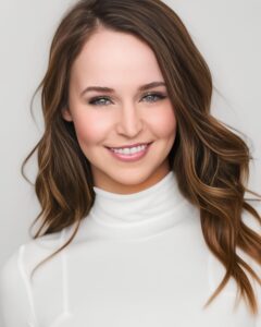 A brown-haired woman, smiling